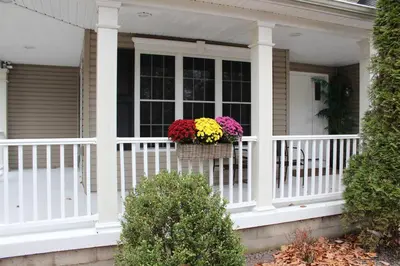 a porch with flowers in a basket on a house at Luxury 4 bedroom house in Pocono Mountains with Hottub in Golf Course Near Lake in Tobyhanna