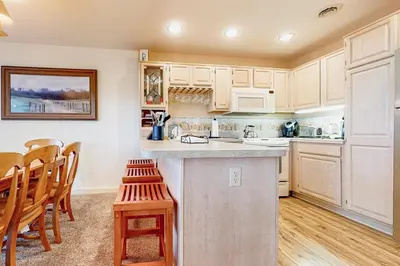 a kitchen with white cabinets and a table and chairs at Big Boulder Base Camp in Lake Harmony
