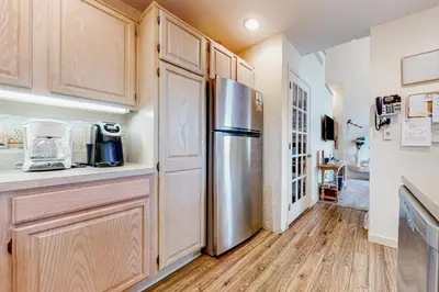 a kitchen with wooden cabinets and a stainless steel refrigerator at Big Boulder Base Camp in Lake Harmony
