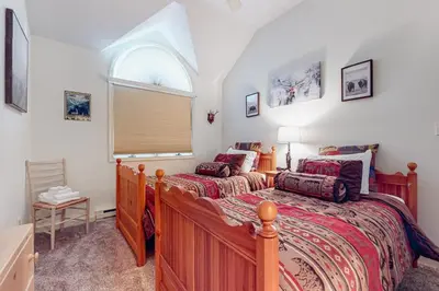 a bedroom with two beds and an arched window at Big Boulder Base Camp in Lake Harmony