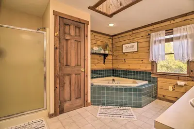 a bathroom with a tub and a shower with a window at Pool, Games and Sauna Mount Joy Countryside Cabin in Mount Joy