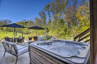a hot tub on a patio with chairs and umbrellas at Pool, Games and Sauna Mount Joy Countryside Cabin in Mount Joy