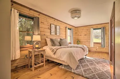 a bedroom with wooden walls and a bed and a table at Pool, Games and Sauna Mount Joy Countryside Cabin in Mount Joy