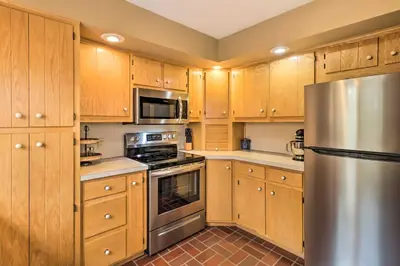 a kitchen with wooden cabinets and a stainless steel refrigerator at Outdoor Theater, Deck and Fire Pit Poconos Retreat in Lake Harmony