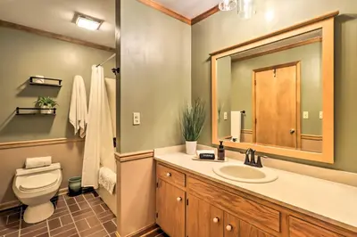 a bathroom with a toilet and a sink and a mirror at Outdoor Theater, Deck and Fire Pit Poconos Retreat in Lake Harmony