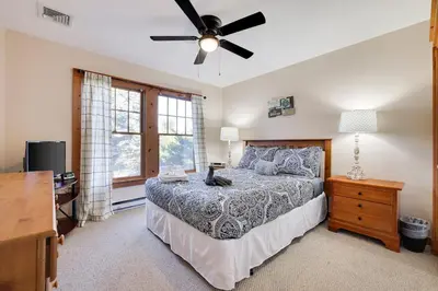 a bedroom with a bed and a ceiling fan at Whispering Pines Cabin Hot Tub Near Ski in Tannersville