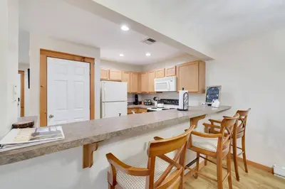 a kitchen with a counter top and wooden cabinets at Whispering Pines Cabin Hot Tub Near Ski in Tannersville
