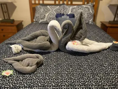 a bed with two swan towels on it at Whispering Pines Cabin Hot Tub Near Ski in Tannersville