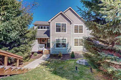 a house with a yard with trees in front of it at Northridge Retreat in Tannersville