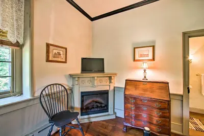 a living room with a television and a fireplace at Beautiful Historic House In Amish Country in Ephrata