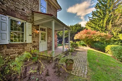 a brick house with a white door and a patio at Beautiful Historic House In Amish Country in Ephrata
