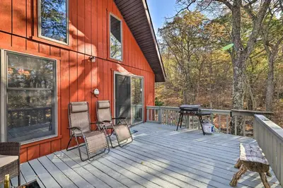 a deck with chairs and a grill on a house at Deck and Forest Views Secluded Cresco Cabin! in Cresco