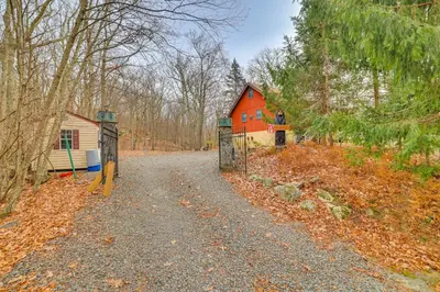 a gate to a house in the middle of a forest at Deck and Forest Views Secluded Cresco Cabin! in Cresco