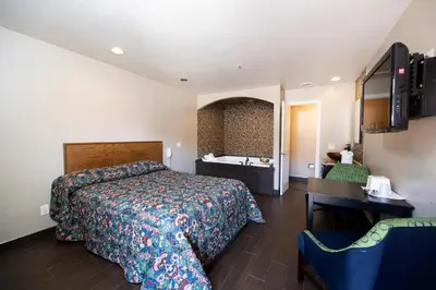 a hotel room with a bed and a sink at Post Road Inn Motel in Avenel