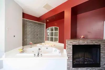 a large bathroom with a fireplace and a tub at Post Road Inn Motel in Avenel