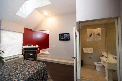 a bedroom with a bathroom with a toilet and a sink at Post Road Inn Motel in Avenel