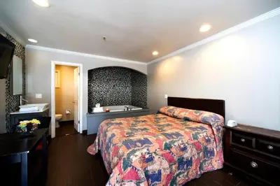 a hotel room with a bed and a sink at Post Road Inn Motel in Avenel