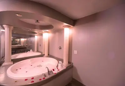 a large bathroom with two tubs and a large mirror at Post Road Inn Motel in Avenel