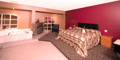 a large bedroom with a bed and a bath tub at Post Road Inn Motel in Avenel