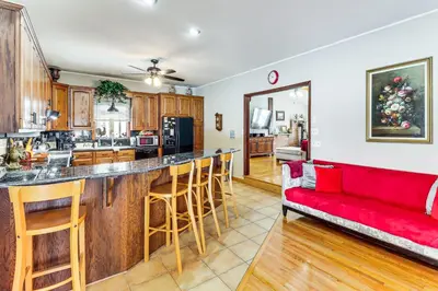 a kitchen and living room with a red couch at 4 Mi to Camelback! Group-Friendly Poconos Cabin in Bartonsville
