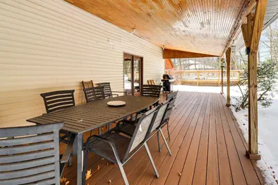 a wooden deck with a wooden table and chairs at 4 Mi to Camelback! Group-Friendly Poconos Cabin in Bartonsville