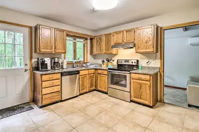a kitchen with wooden cabinets and stainless steel appliances at Hot Tub and Game Room Peaceful Poconos Home! in Lake Harmony