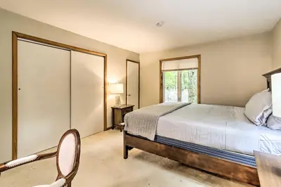 a bedroom with a bed and a table and a chair at Hot Tub and Game Room Peaceful Poconos Home! in Lake Harmony