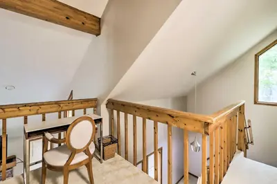 a wooden staircase with a chair in a room at Hot Tub and Game Room Peaceful Poconos Home! in Lake Harmony