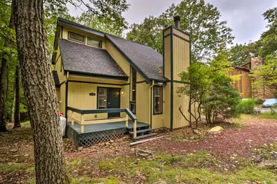 a yellow tiny house in the woods at Hot Tub and Game Room Peaceful Poconos Home! in Lake Harmony