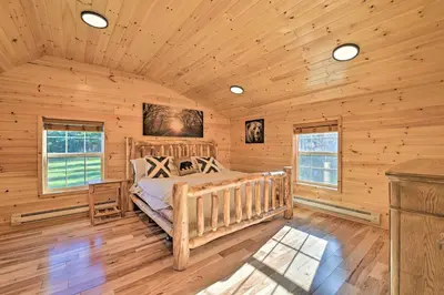 a log cabin bedroom with a bed and windows at Unadilla Cabin on 50 Acres and Fire Pit and Creek in Unadilla