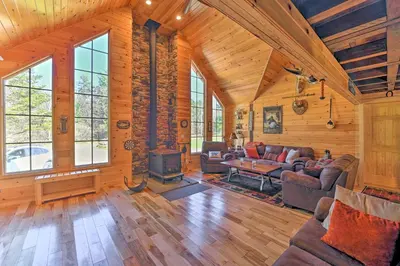 a living room with a couch and a fireplace in a cabin at Unadilla Cabin on 50 Acres and Fire Pit and Creek in Unadilla