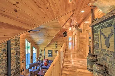 a log home hallway with wooden ceilings and a stone wall at Unadilla Cabin on 50 Acres and Fire Pit and Creek in Unadilla