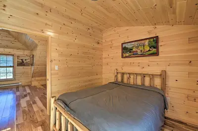 a bedroom with a bed in a log cabin at Unadilla Cabin on 50 Acres and Fire Pit and Creek in Unadilla