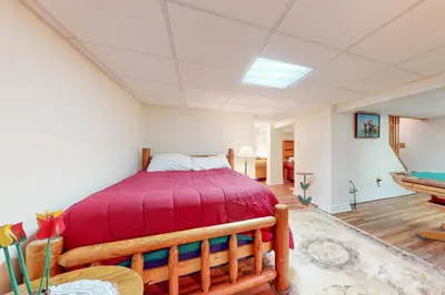 a bedroom with a bed with a red bedspread at Arrowhead Lake Leisure in Pocono Lake