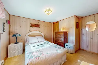 a bedroom with a bed and a wooden wall at Arrowhead Lake Leisure in Pocono Lake