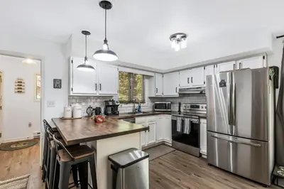 a kitchen with white cabinets and a stainless steel refrigerator at Welcome to The Mountain Escape! in Albrightsville