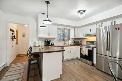 a kitchen with white cabinets and a stainless steel refrigerator at Welcome to The Mountain Escape! in Albrightsville