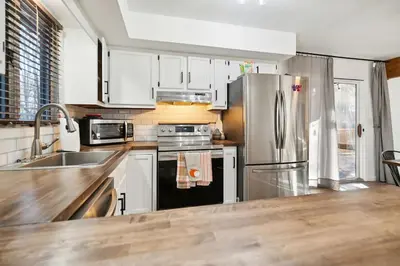 a kitchen with white cabinets and a stainless steel refrigerator at Welcome to The Mountain Escape! in Albrightsville