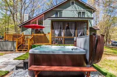a hot tub sitting in front of a house at Welcome to The Mountain Escape! in Albrightsville