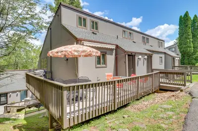 a house with a large deck with an umbrella at Community Indoor Pool Tannersville Townhome in Tannersville
