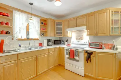 a kitchen with wooden cabinets and white appliances at Community Indoor Pool Tannersville Townhome in Tannersville