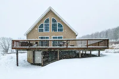 a wooden deck in the snow in front of a house at Bluestone Hill House in Walton