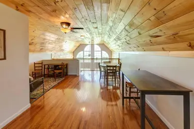 a large room with wooden ceilings and tables and chairs at Bluestone Hill House in Walton