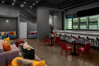 a restaurant with tables and chairs and a bar at Aloft New York Chelsea in New York
