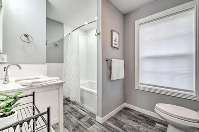a bathroom with a toilet and a sink and a window at Community Beach and Lake Pocono Summit Escape in Pocono Summit