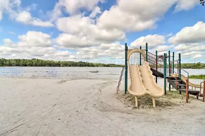 a playground on the beach next to the water at Community Beach and Lake Pocono Summit Escape in Pocono Summit