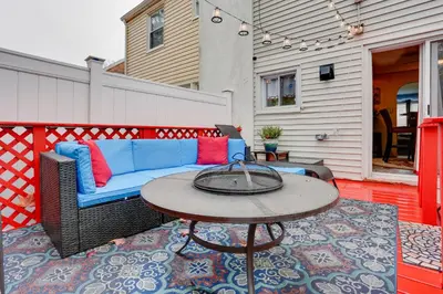 a patio with a blue couch and a table at Newark Home with Deck and Fire Pit, 16 Mi to NYC! in Newark