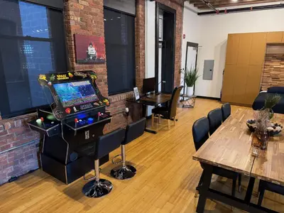 a room with a video game and a table and chairs at Brick City Loft in Newark
