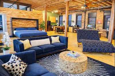 a living room with blue couches and a table at Brick City Loft in Newark