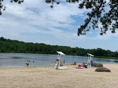 a group of people on a beach near the water at Modern Home near Lake w HotTub, Game Room, Fireplace in Albrightsville